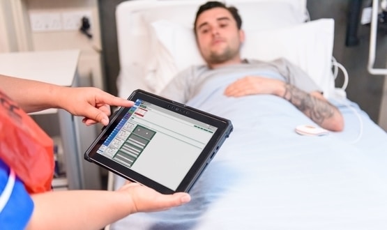 A nurse examines a electronic patient chart on a tablet