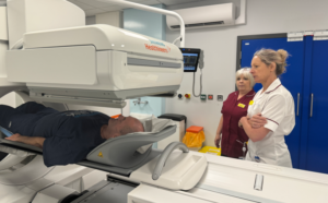 Two female clinicians monitor a male patient undergoing scanning in Royal Shrewsbury Hospital's new gamma camera