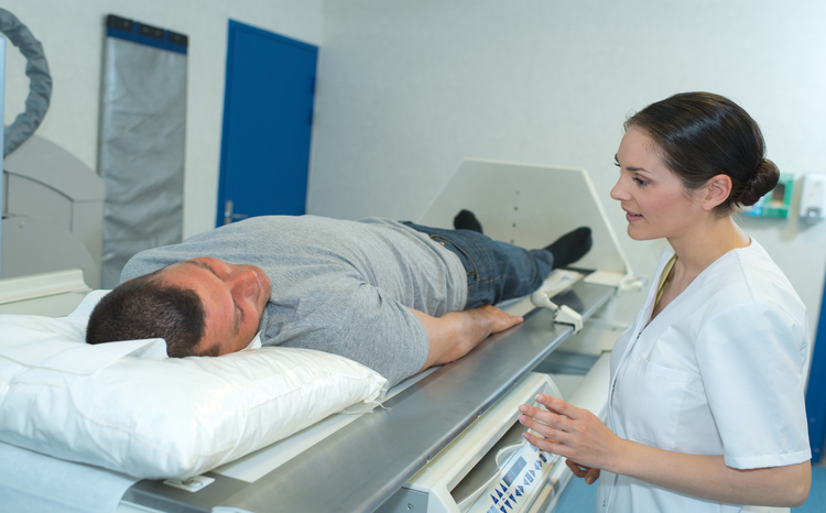 male patient ready to undergo mri assisted by doctors